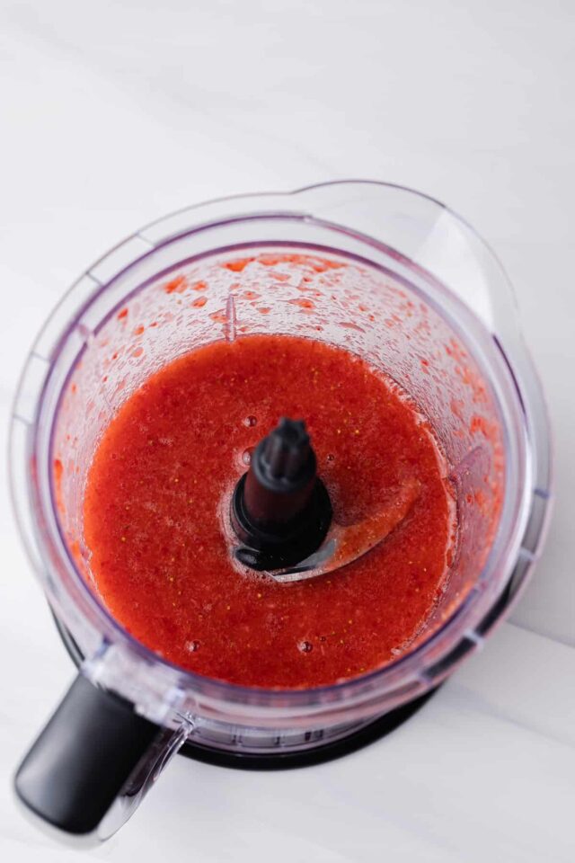 strawberry puree in a mesh strainer