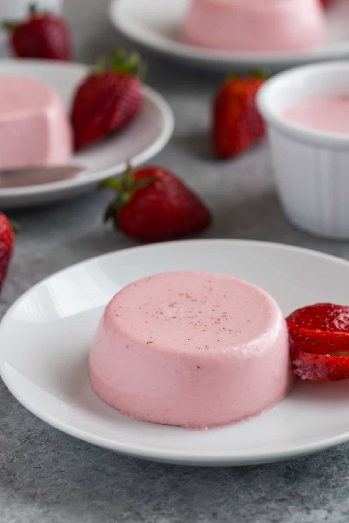 Strawberry panna cotta on a white plate.
