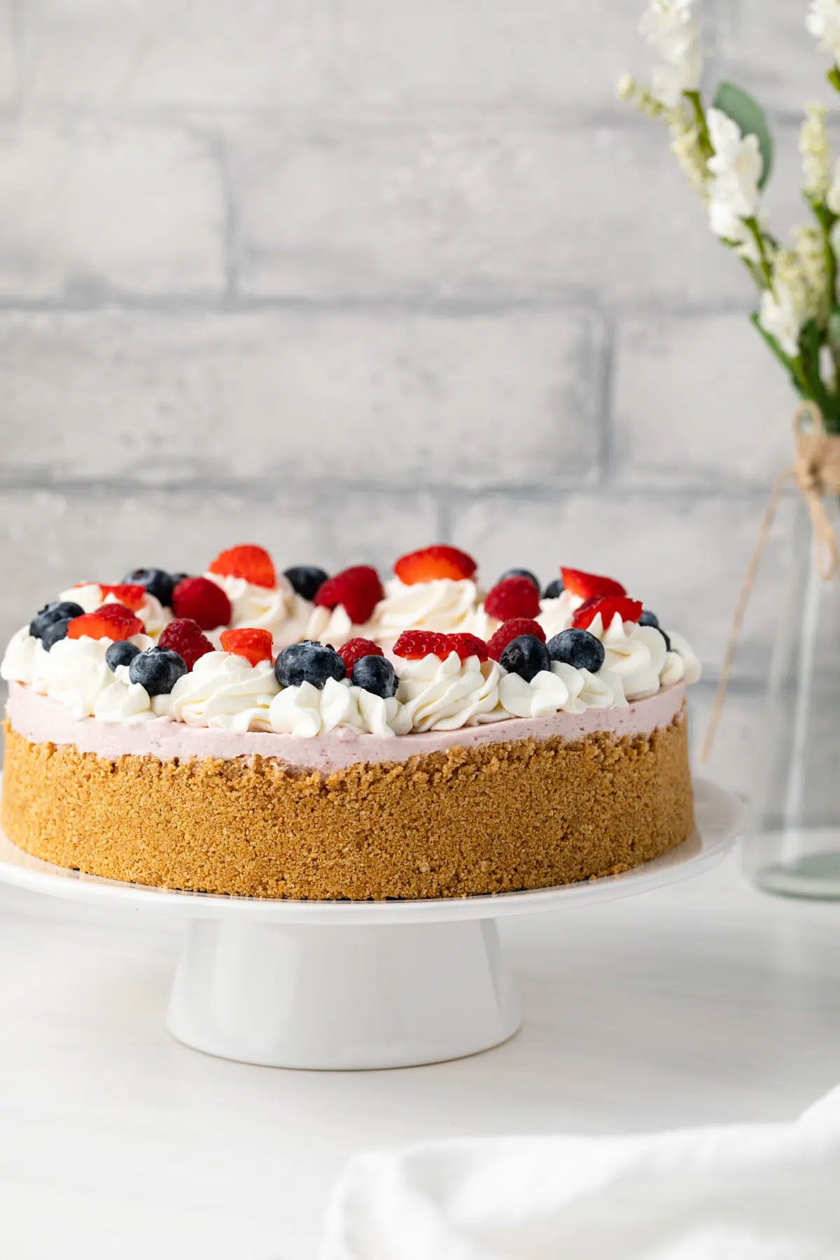 No bake berry cheesecake on white serving platter.