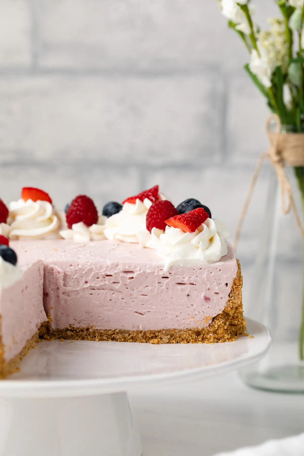 No bake berry cheesecake with a slice taken out.