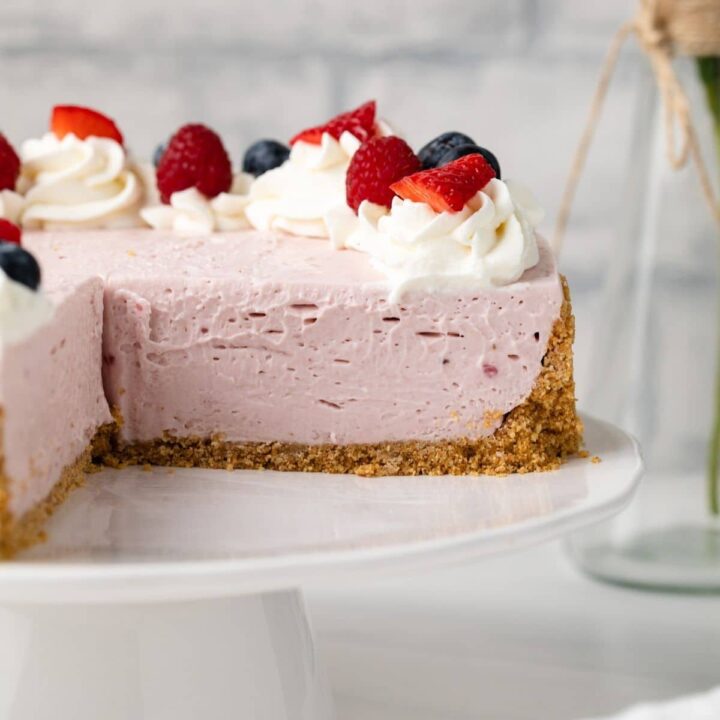 No bake berry cheesecake with a slice taken out.