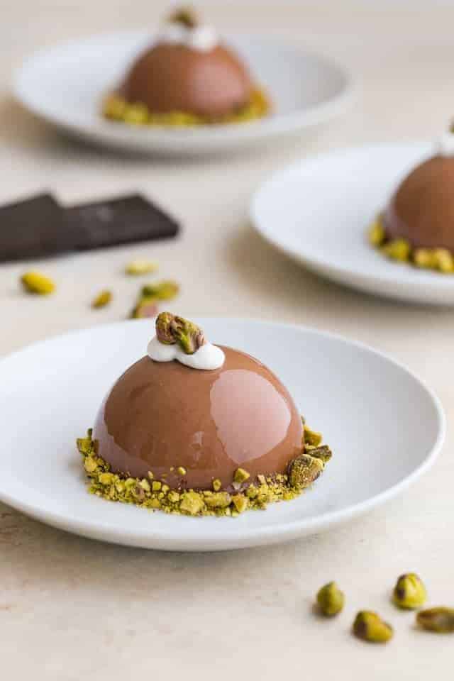 Chocolate Pistachio Dome on a white plate.