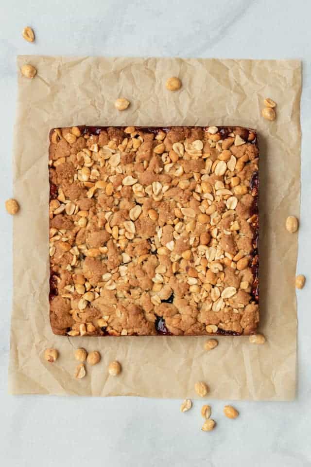 Uncut peanut butter and jelly bars on brown parchment paper.