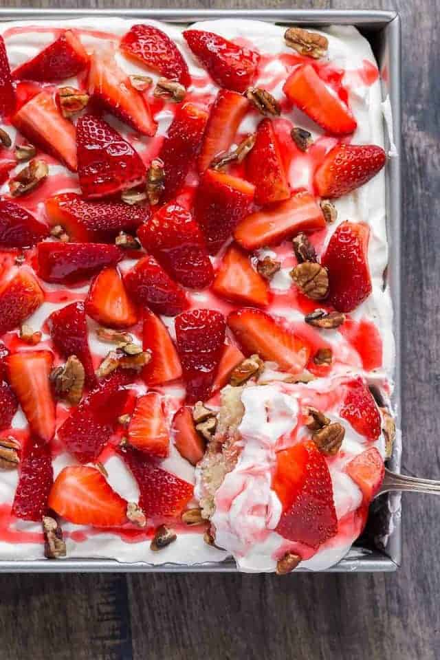 overhead view of Strawberries and Cream Icebox Cake with a spoon scooping out a slice