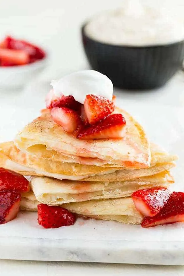 Front view of a stack of Strawberry Cheesecake Quesadillas on a marble platter.