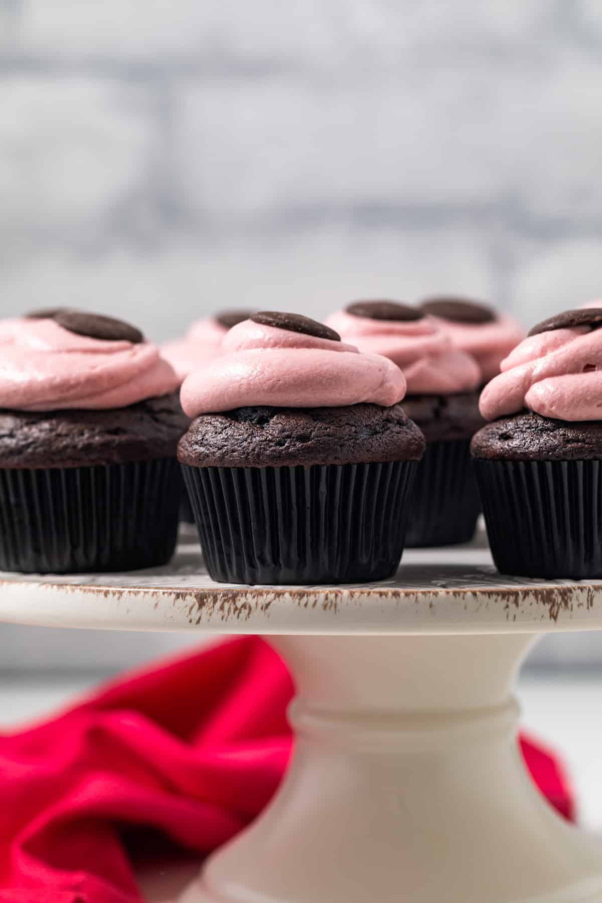 Chocolate raspberry cupcakes on a cake stand.