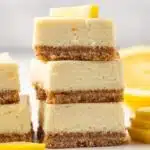 Three lemon cheesecake bars stacked.