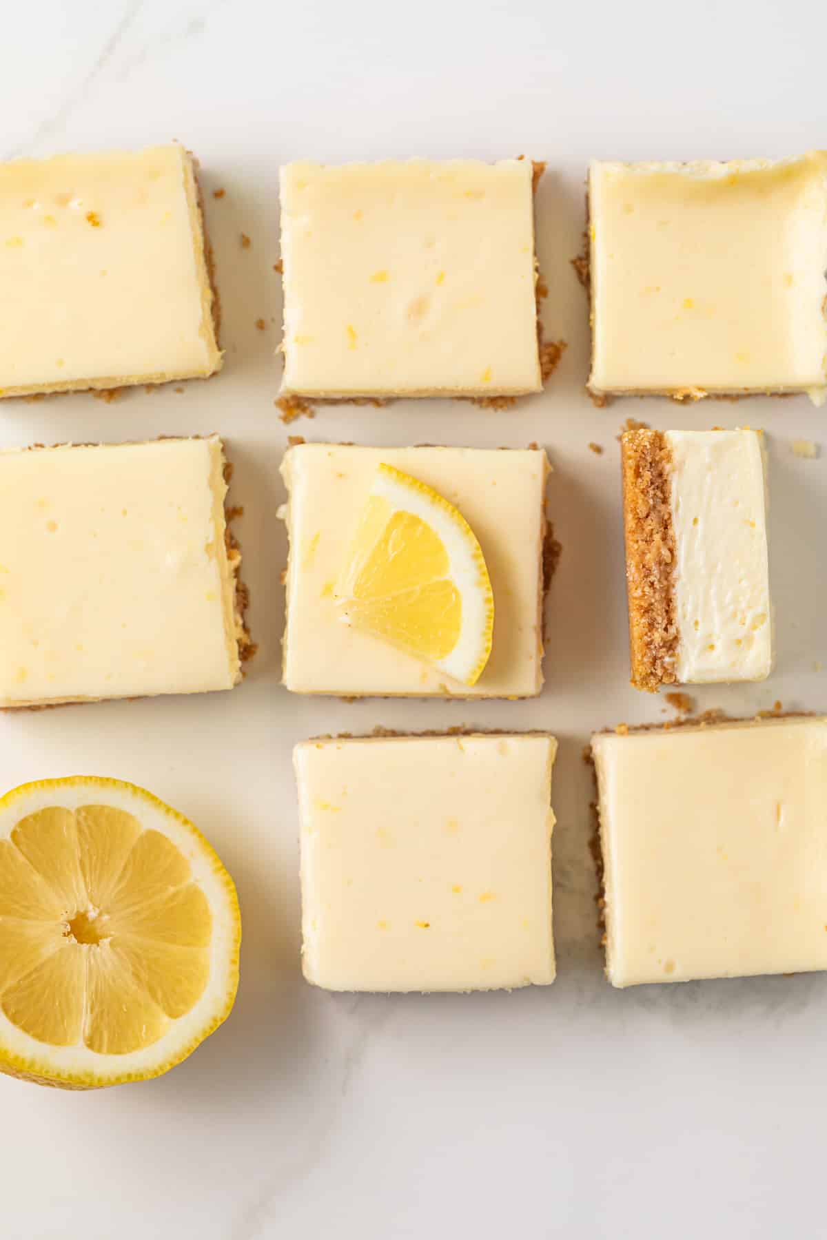 Lemon cheesecake bars with lemon wedge decorations.