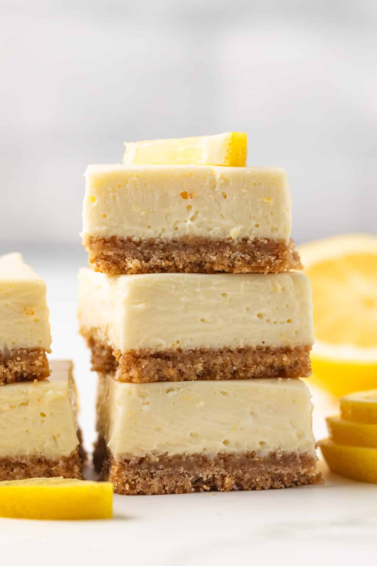 Three lemon cheesecake bars stacked.