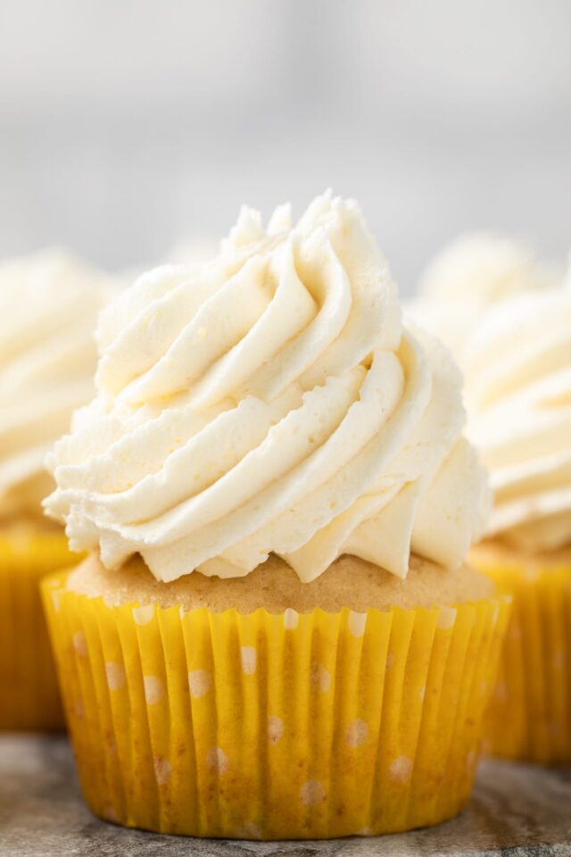 Pineapple frosting swirled over a cupcake.
