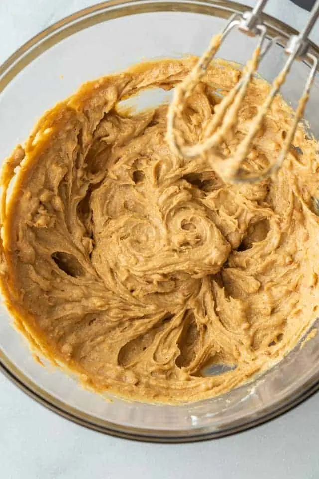 Wet ingredients for peanut butter bars mixed in a glass bowl.