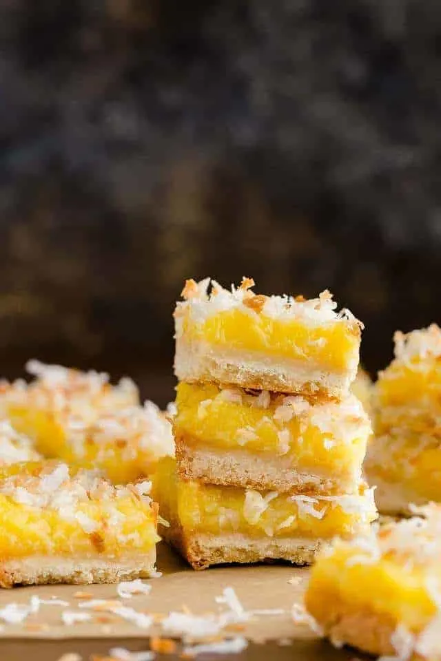 Coconut lemon bars stacked on a table.
