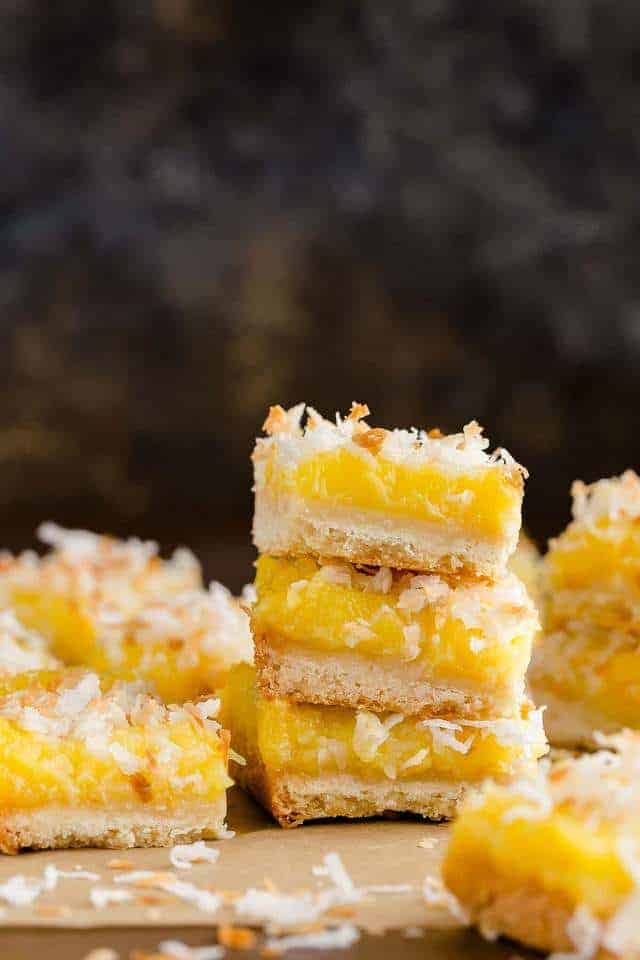 Coconut lemon bars stacked on a table.