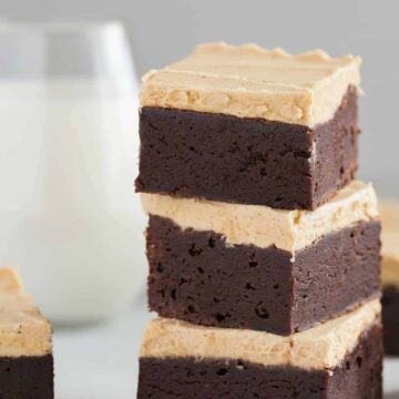 a stack of three fudgy brownies with peanut butter frosting