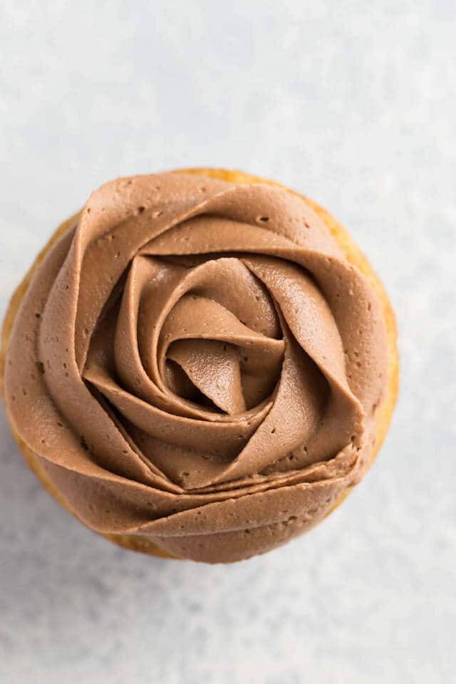 nutella frosting piped in a rose shape over the top of a cupcake