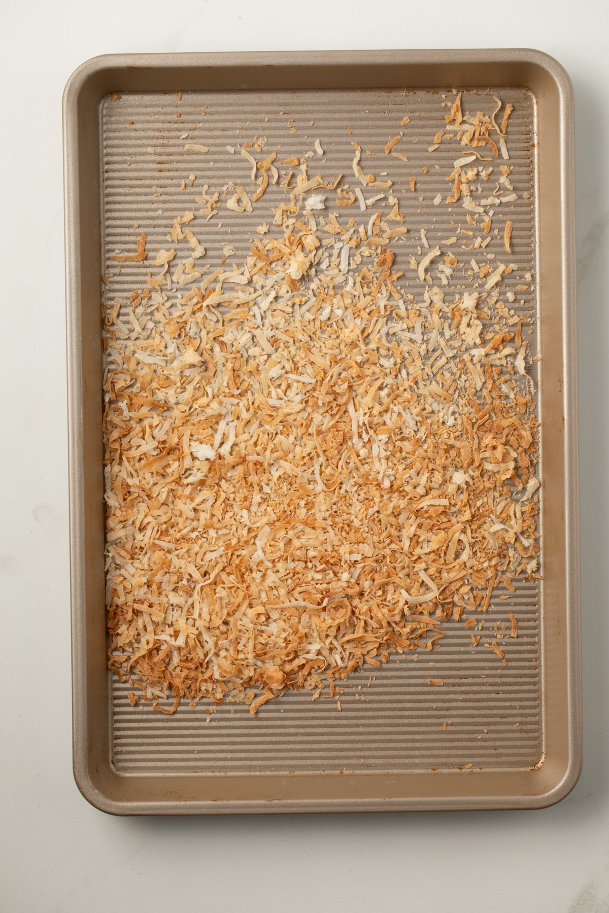 Toasted coconut on a baking sheet.