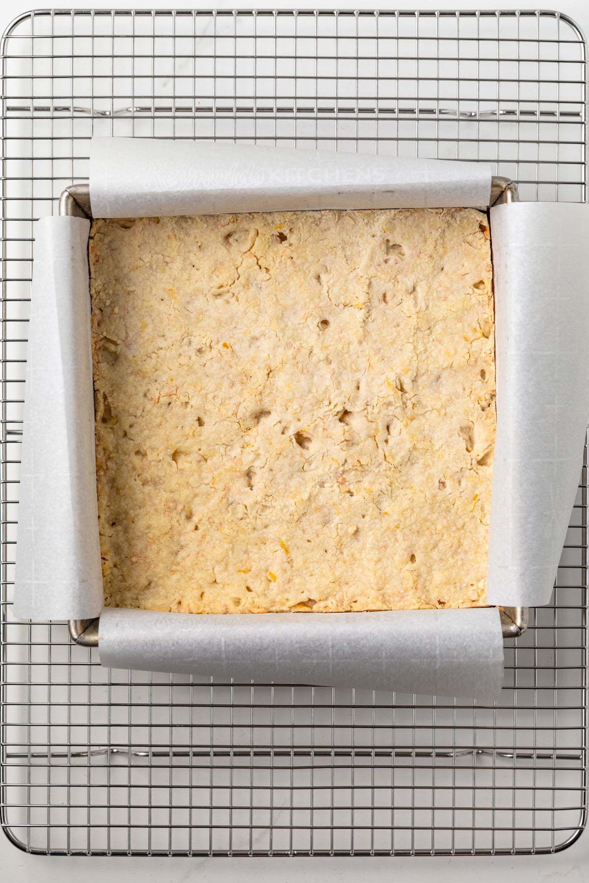 Coconut shortbread crust in a square pan.