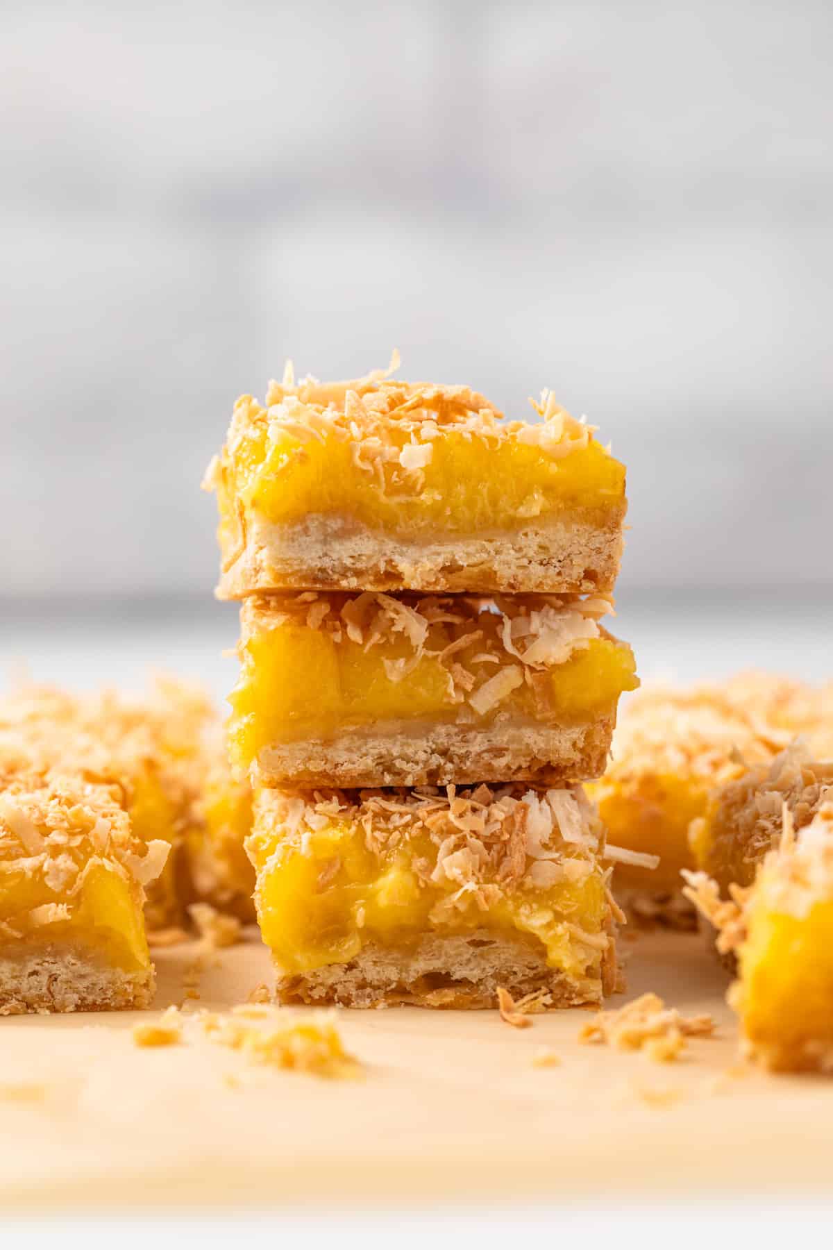 Coconut lemon bars stacked three high.
