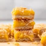 Coconut lemon bars stacked three high.