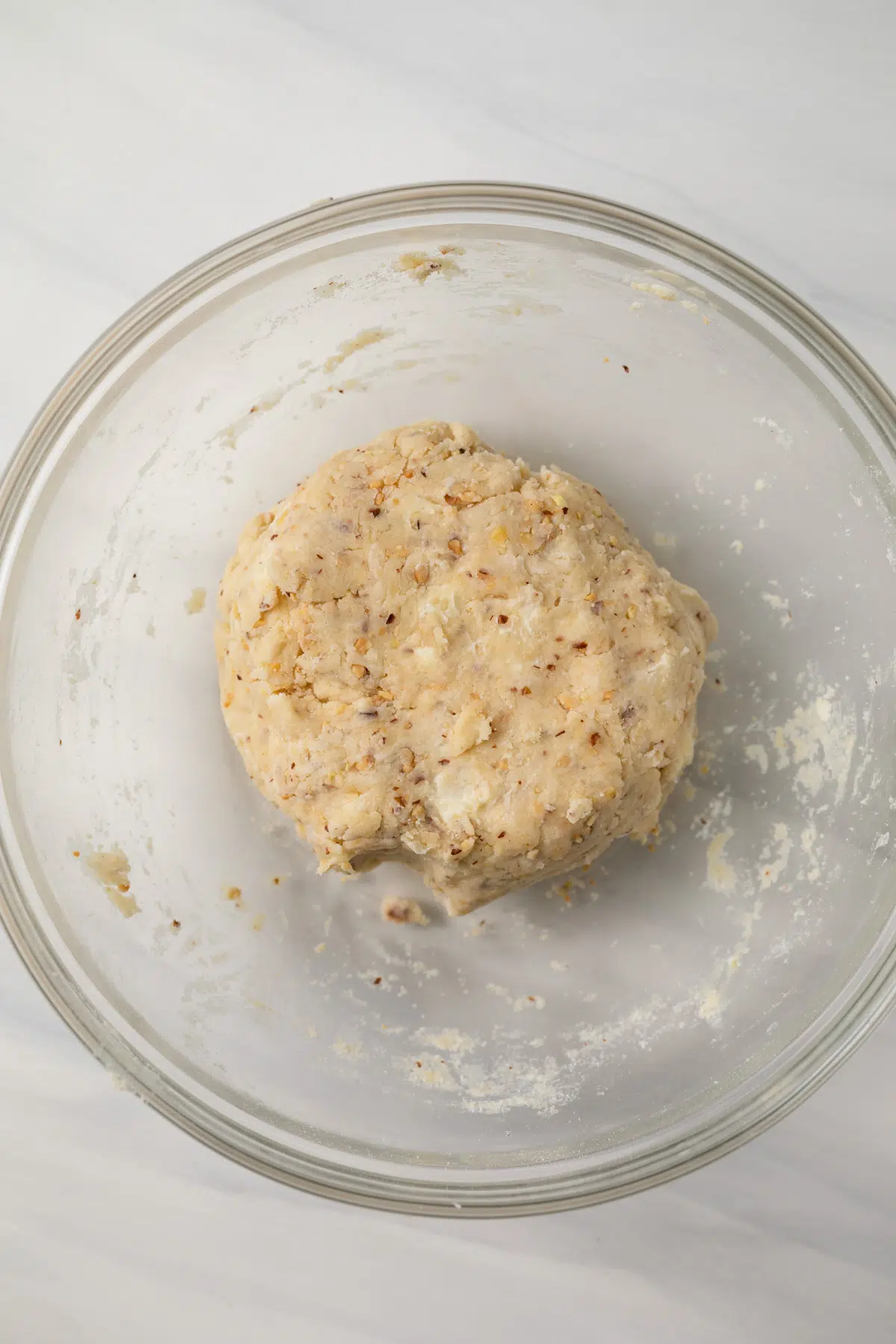 Almond pastry dough in glass bowl.