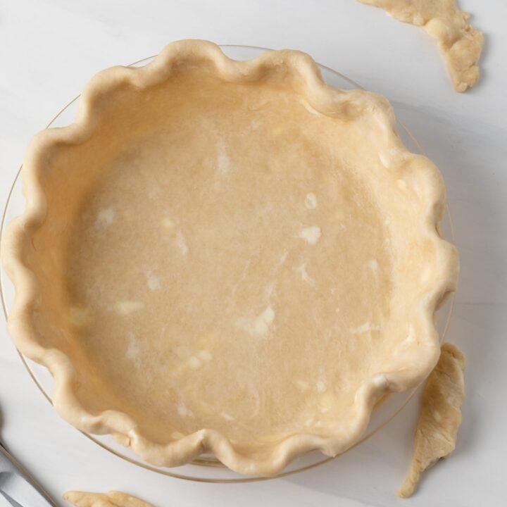 overhead of unbaked pie crust in glass pie pan