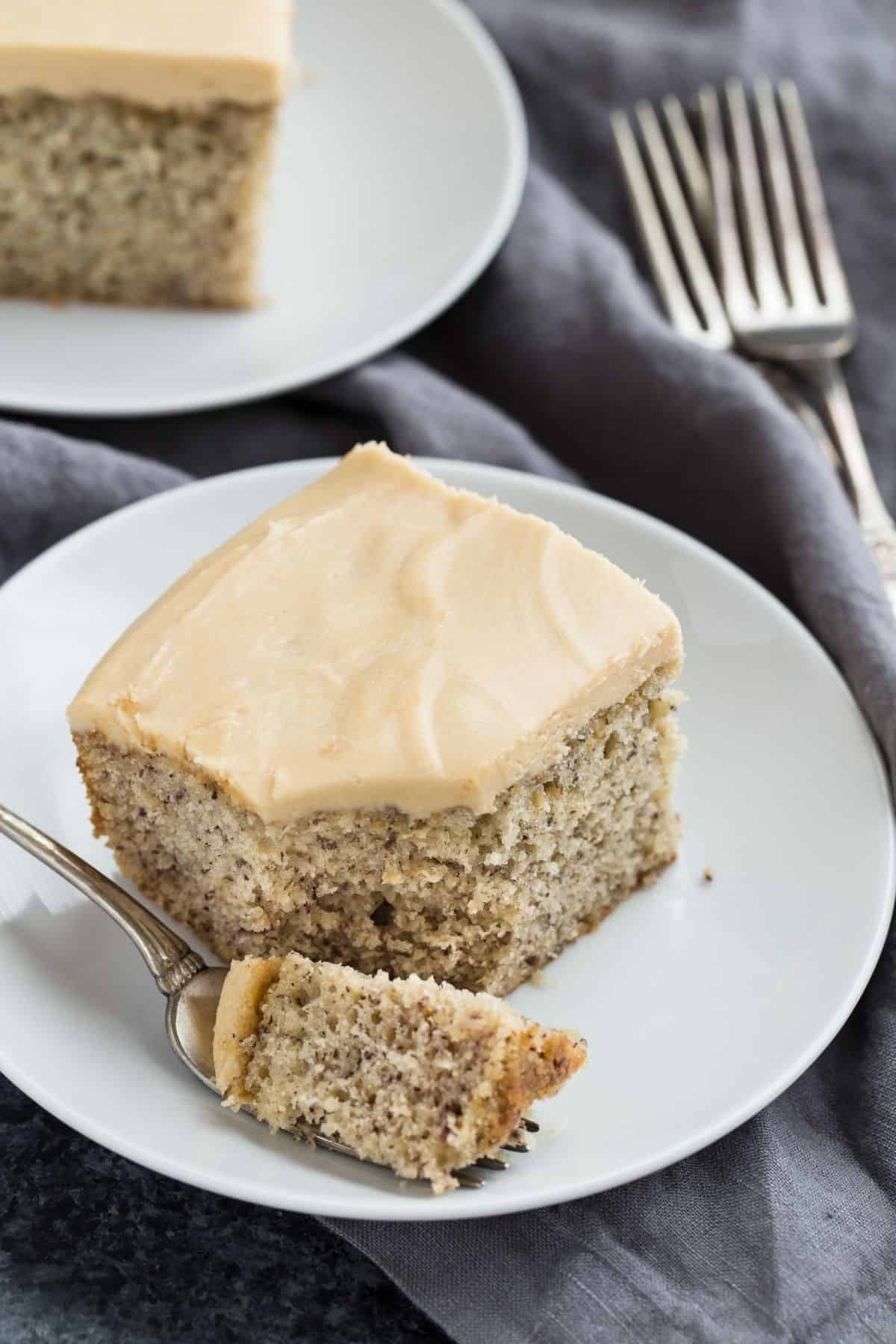 Easy Banana Cake on a plate with a fork taking a bite out.