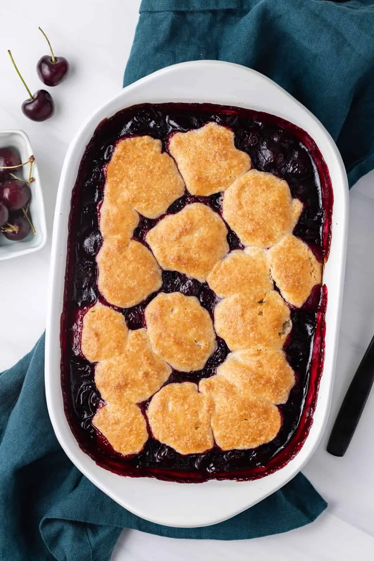 Freshly baked cherry cobbler in a white baking dish