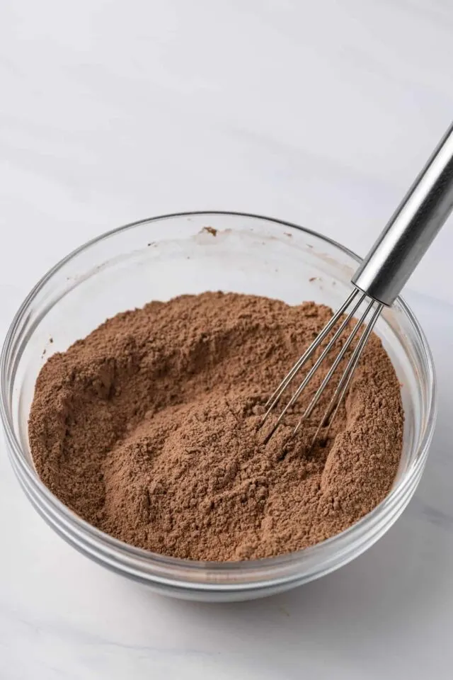 Dry ingredients for baked chocolate donuts being whisked