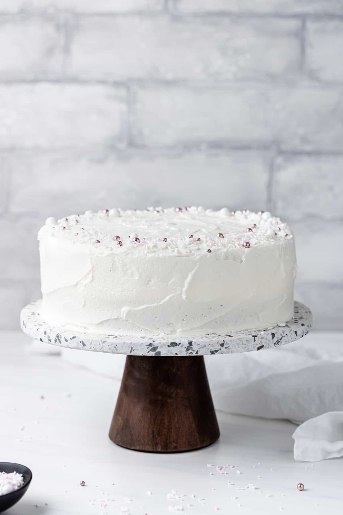 The best white cake with buttercream frosting on a serving stand