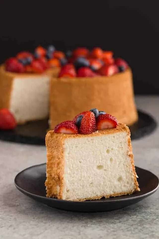 side view of a slice of angel food cake on a black plate