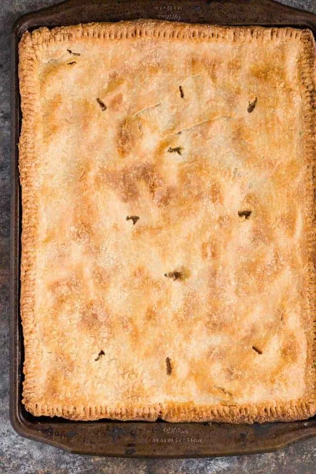 An apple slab pie baked to golden perfection in a large baking sheet.