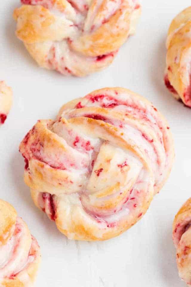 Close up view of cranberry orange sweet rolls with glaze.