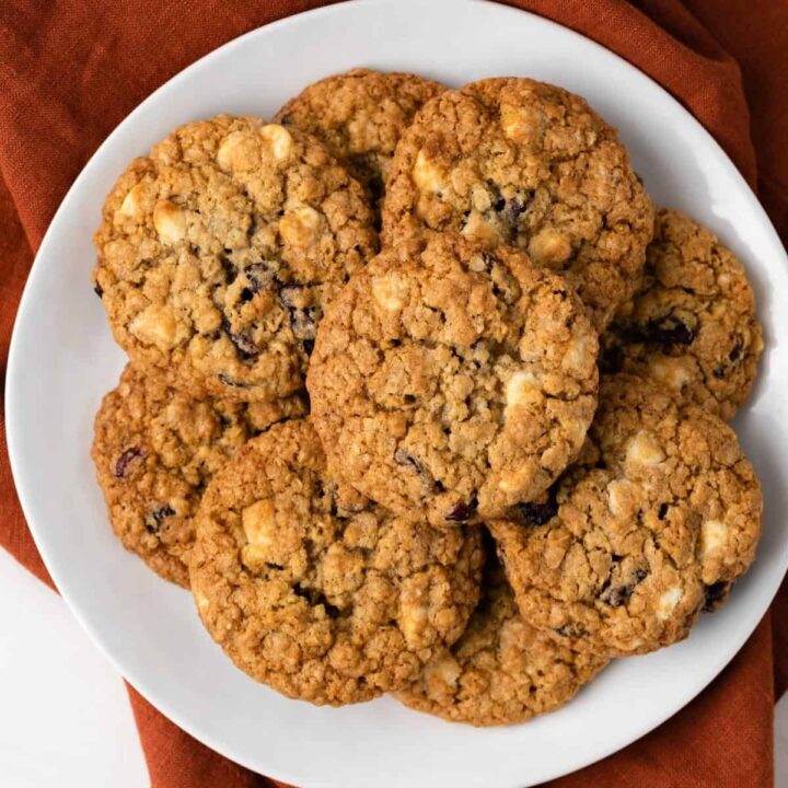 Overhead view of white chocolate oatmeal cookies on a white plate