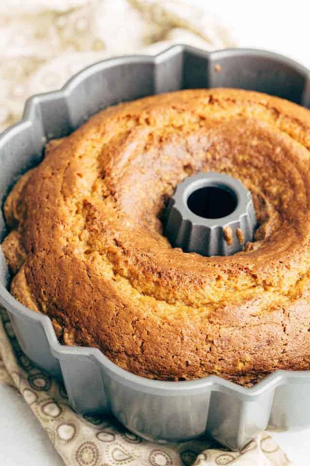 Baked Pumpkin Bundt Cake in the pan sitting on a brown and white napkin.
