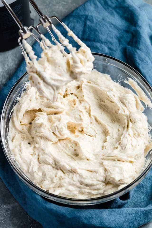 Whipped eggnog buttercream frosting in a glass bowl.
