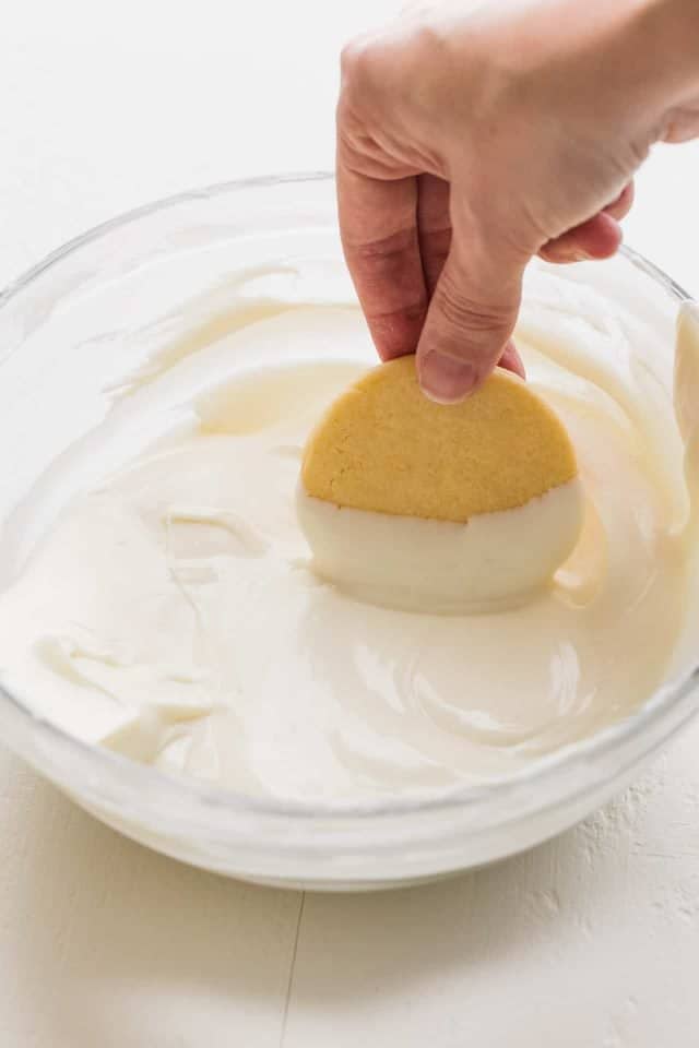 Peppermint Cookie being dipped in white chocolate.