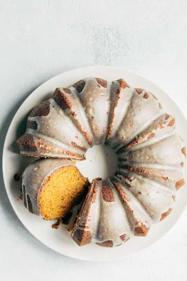 An overhead shot of a pumpkin bundt cake with a slice cut and tilted to the side.