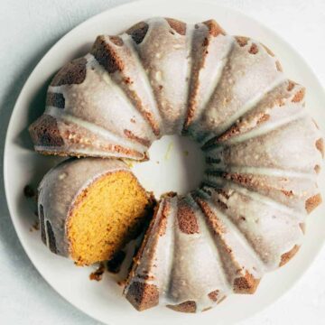 An overhead shot of a pumpkin bundt cake with a slice cut and tilted to the side.