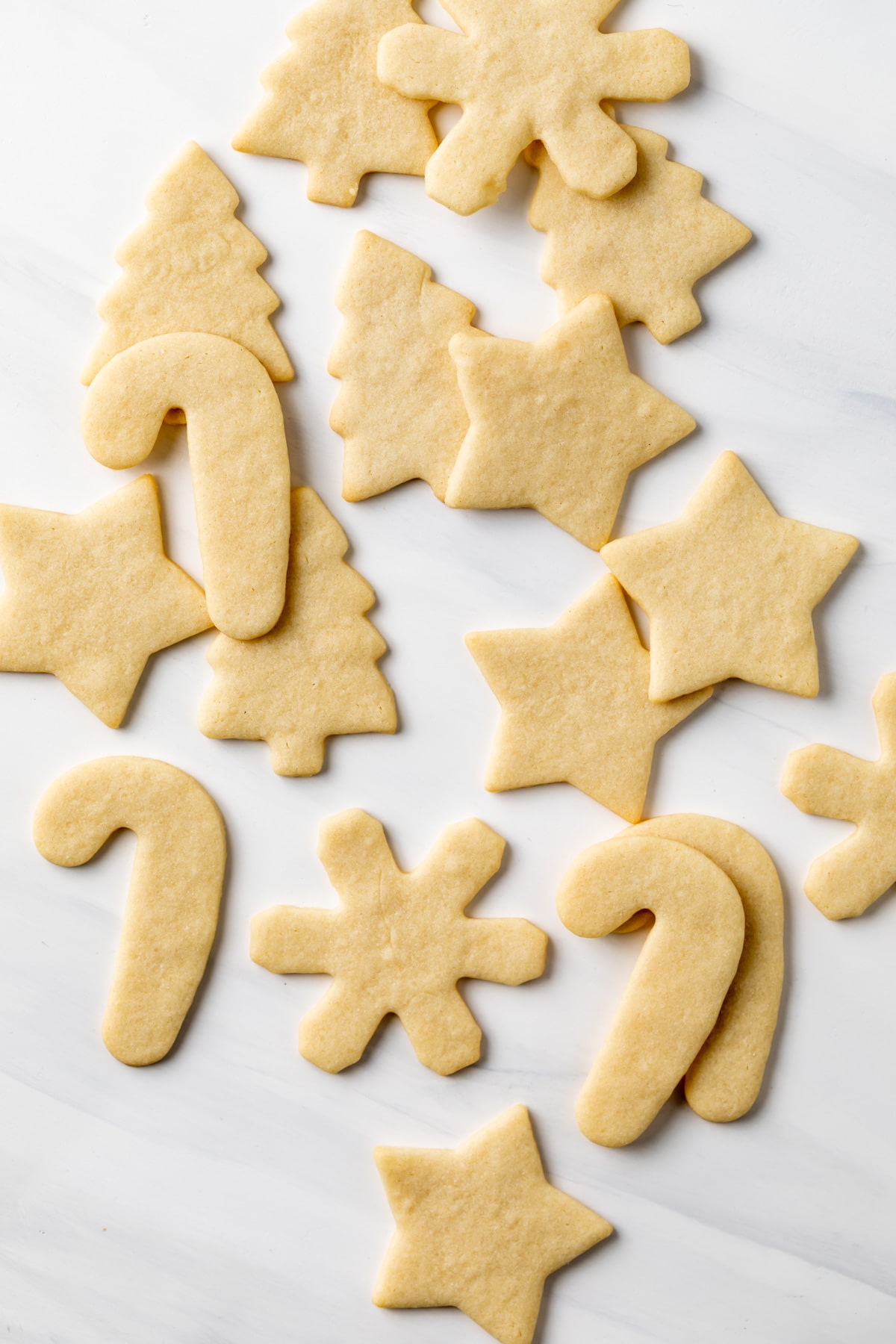 cut out sugar cookies scattered on a white background