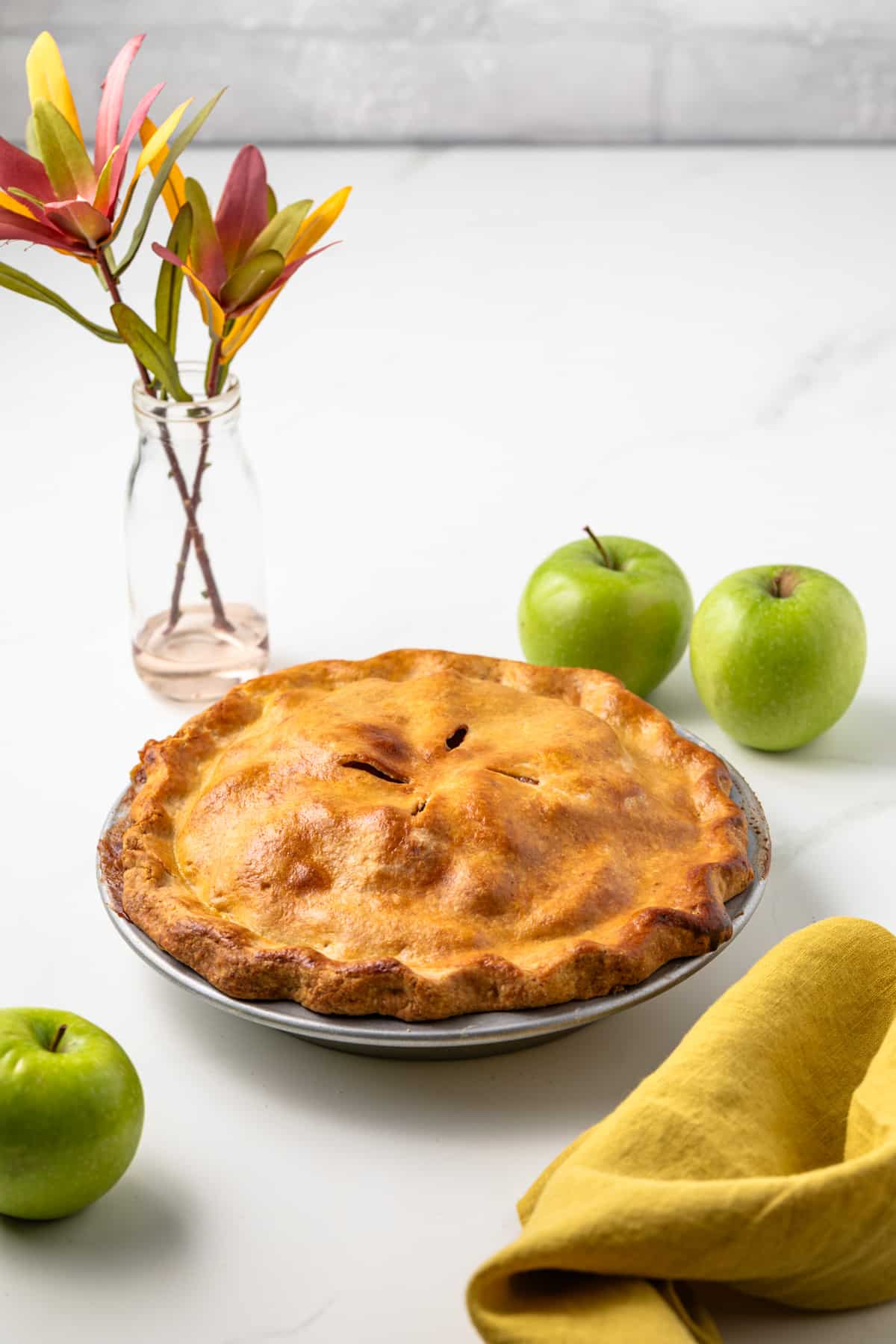 Side view of brown butter apple pie in a pie pan.