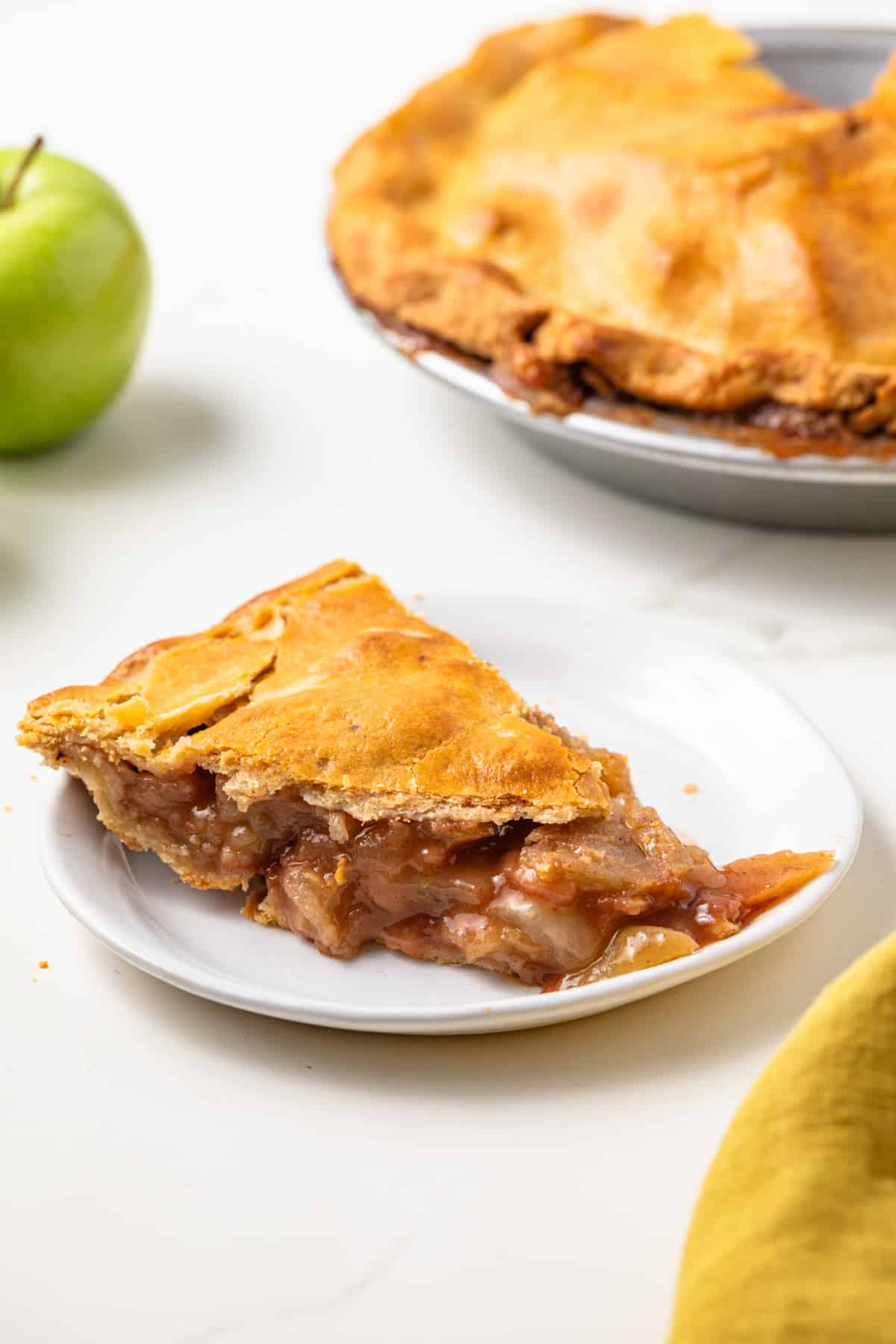 Slice of apple pie with brown butter crust on a plate.