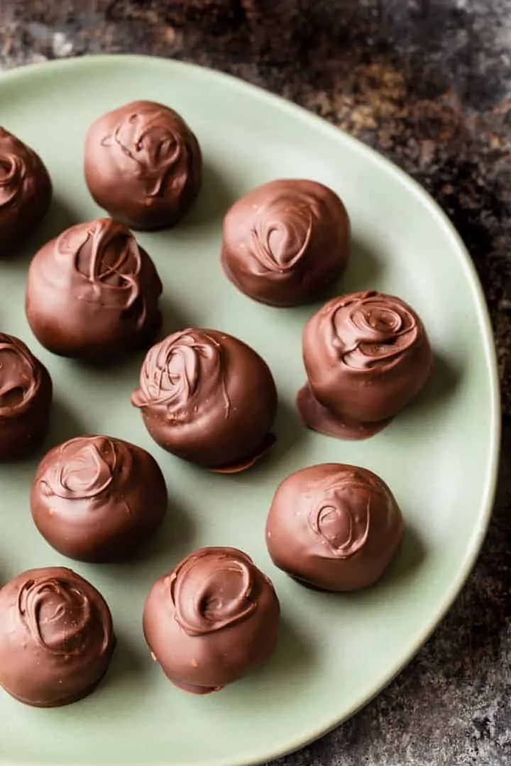 high angled view of chocolate chip cookie dough truffles on a green plate