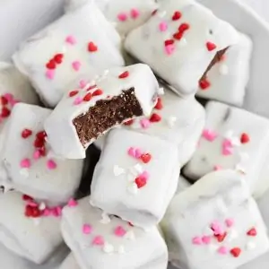 Mexican hot chocolate fudge coated in white chocolate stacked on a white plate.