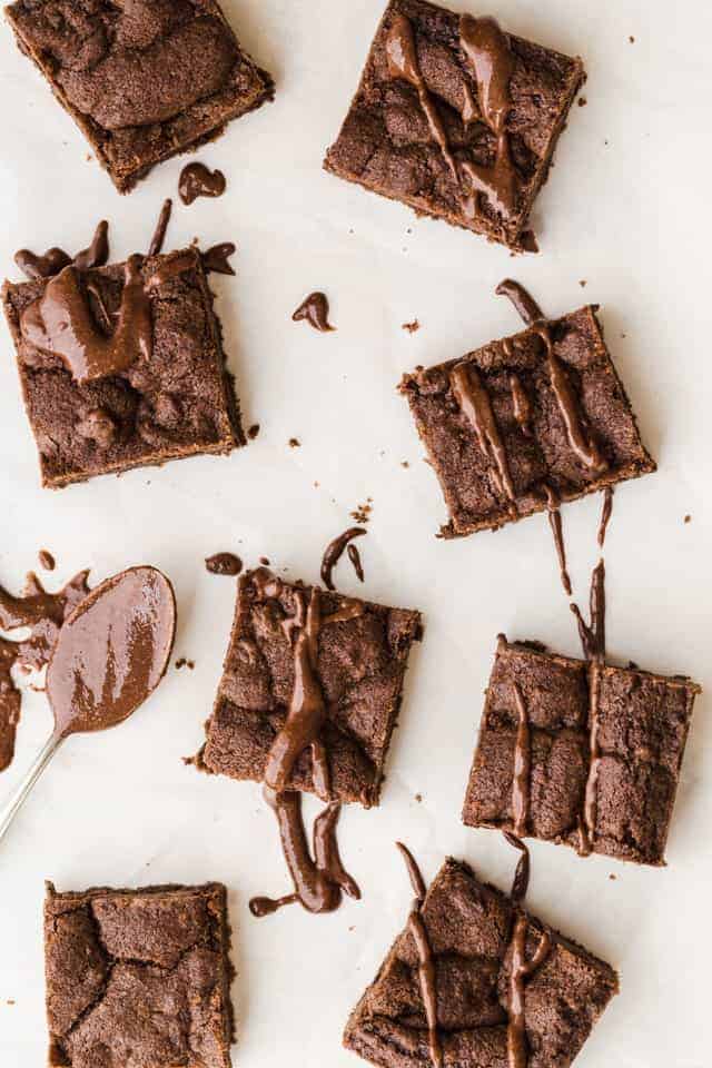 Chocolate nutella cookie bars drizzled with nutella on white parchment paper.