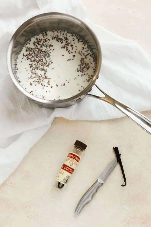 Milk, anise seed, and vanilla bean in a stainless steel pot.