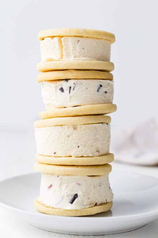 Soft ice cream sandwich cookies stacked four high on a white plate.