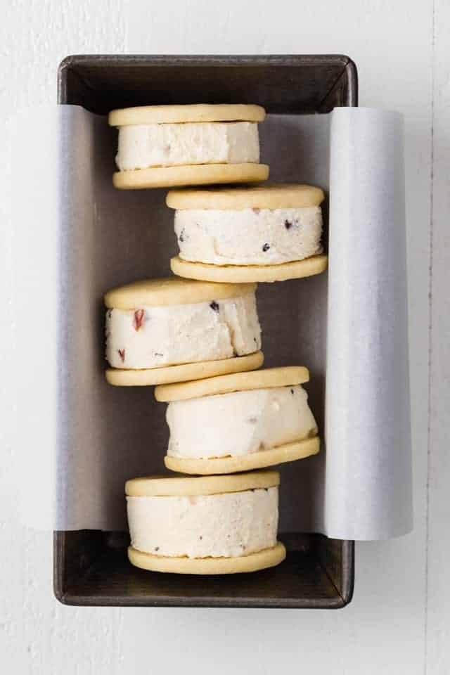 Soft ice cream sandwich cookies arranged in a loaf pan lined with white parchment paper.