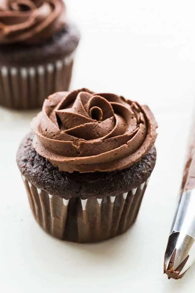 chocolate buttercream frosting piped over chocolate cupcakes