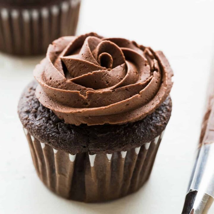 chocolate buttercream frosting piped over chocolate cupcakes