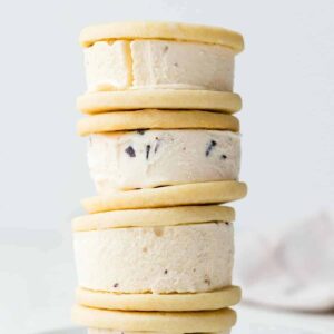 Soft ice cream sandwich cookies stacked four high on a white plate.